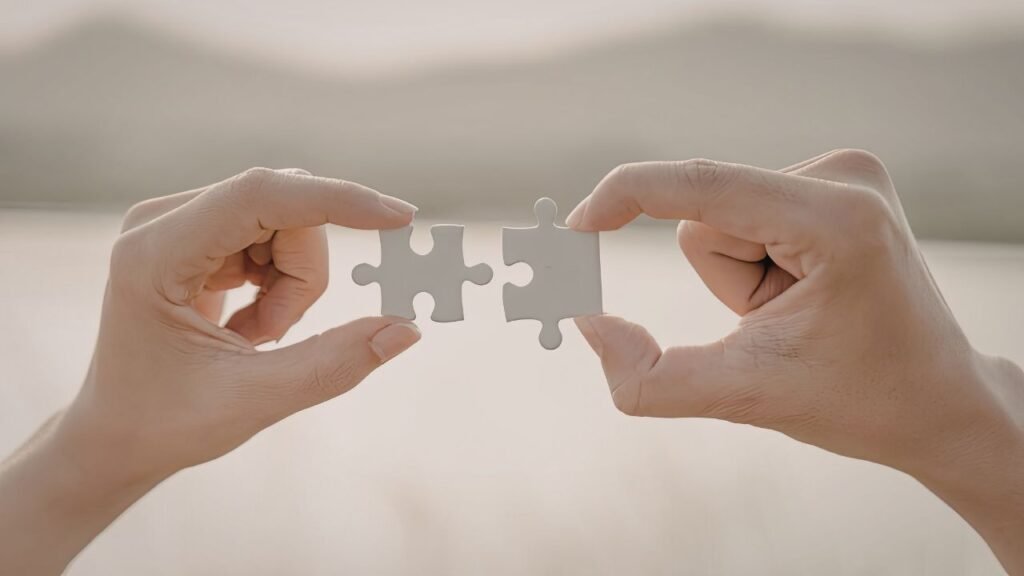 12 Signs You’re Searching for Meaning in Your Life and What to Do Next 4 Hands connecting puzzle pieces together, illustrating signs You’re Searching for Meaning in Your Life and trying to complete life’s purpose
