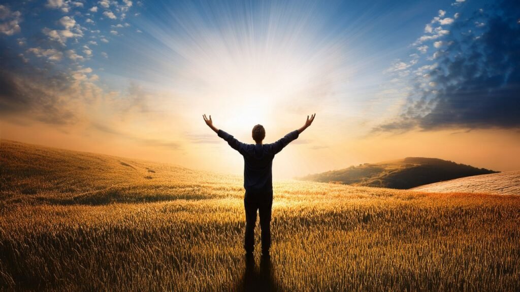 12 Signs You’re Searching for Meaning in Your Life and What to Do Next 5 Person standing in a glowing sunrise field with arms raised, symbolizing signs You’re Searching for Meaning in Your Life and personal awakening
