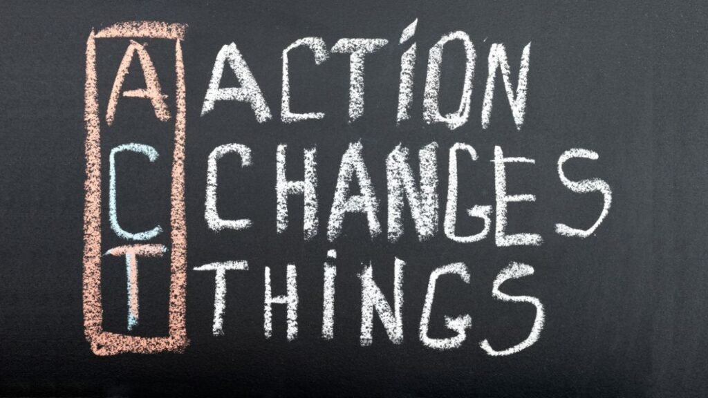 Chalkboard with motivational phrase "Action Changes Things" written in white chalk, with letters "A," "C," and "T" highlighted in a vertical orange rectangle. The text emphasizes importance of taking action to create change.