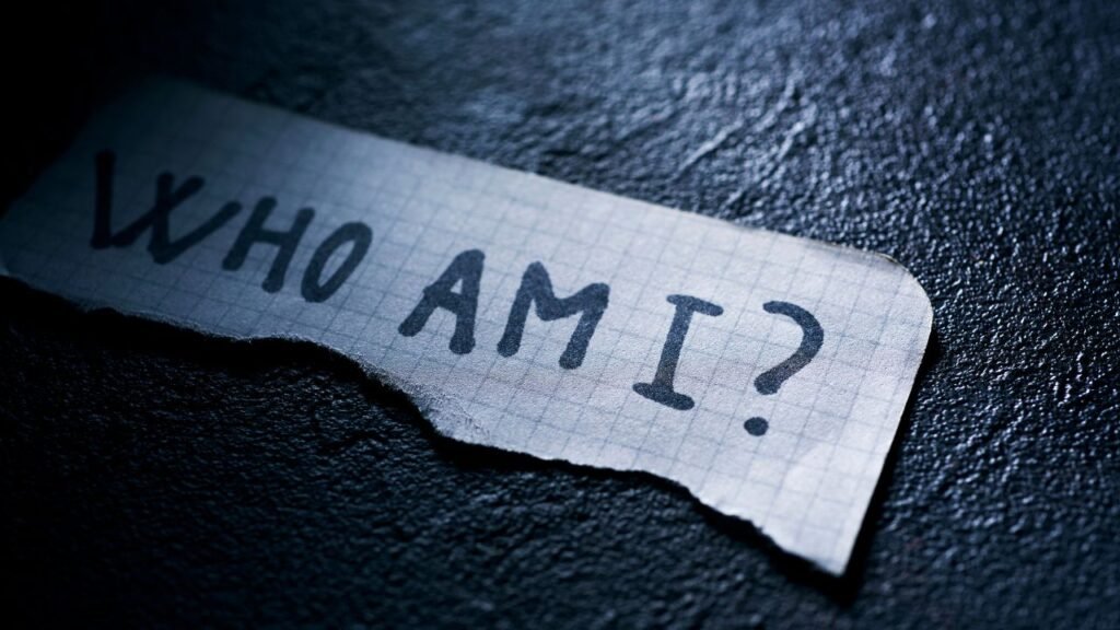 5 Stages of Identity Shift During Personal Growth and How to Support Yourself 9 Paper note reading “Who Am I” symbolizing self-questioning and the early Stages of Identity Shift