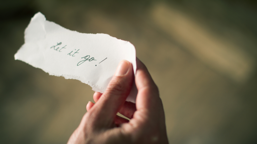 How to Let Go of Your Old Self Without Fear 5 Hand holding a note that says “Let it go,” capturing the journey of how to let go of your old self and start fresh