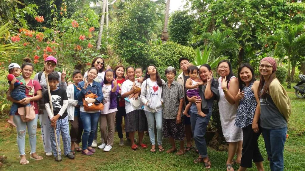 Ninety-Three Years of Love: What Lola Inay Taught Me About a Life Well Lived 3 Family group portrait in a landscaped tropical garden with colorful flowers and trees