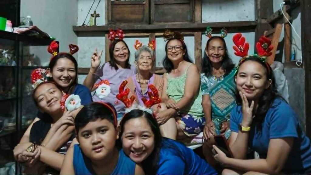 Ninety-Three Years of Love: What Lola Inay Taught Me About a Life Well Lived 6 Multi-generational family wearing festive holiday headbands while posing together inside a traditional home